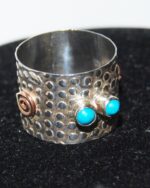 Modernist hammered effect silver ring, with turquoise highlights.